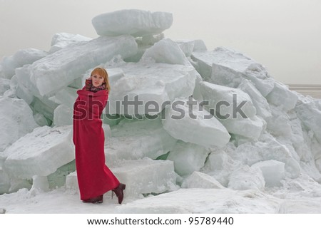 Woman in red cape against blocks of ice