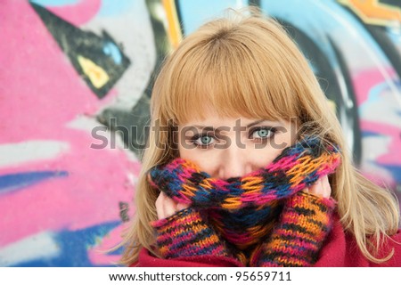 Girl with the multicolored scarf against the graffiti picture