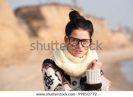 Girl with thick-rimmed glasses standing on seaside