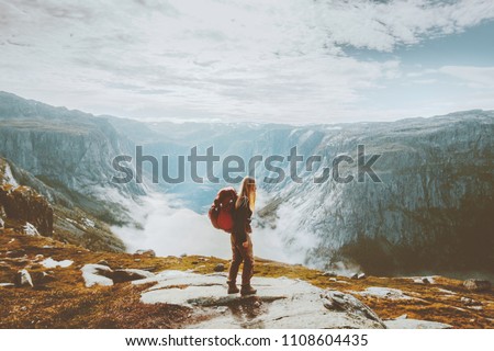 Solo traveling girl hiking with backpack in mountains adventure journey lifestyle vacations weekend getaway in Norway