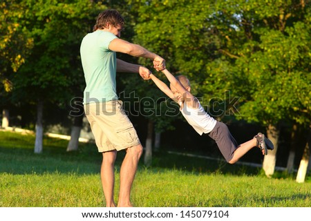 Family Father Man and Son Boy playing Outdoor park flying round Happiness emotion with summer nature on background