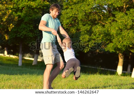 Family Father Man and Son Boy playing Outdoor park flying round Happiness emotion with summer nature on background