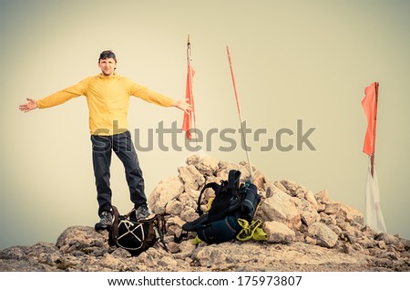 Man Traveler with hands raised on Mountain summit Traveling Mountaineering and freedom concept fog on background
