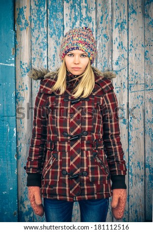 Sad Woman wearing knitted hat and mittens trendy scandinavian Lifestyle melancholy and solitude concept winter time with old wooden background