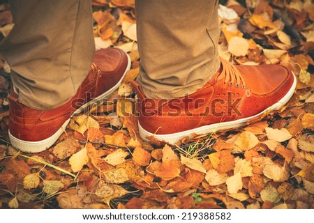 Feet Man walking on fall leaves Outdoor with Autumn season nature on background Lifestyle Fashion trendy style