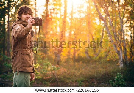 Young Man with retro photo camera outdoor Lifestyle sunlight forest nature on background