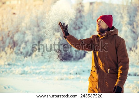 Young Man in hat playing with snow Outdoor Winter Lifestyle vacations nature on background