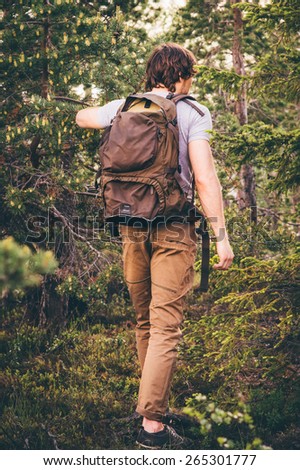 Young Man hiking in forest with backpack Travel Lifestyle and outdoor recreation summer vacations concept