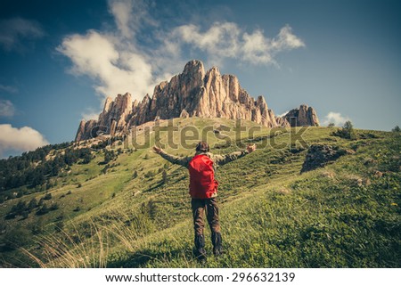 Young Man with backpack raised hands relaxing outdoor Travel Lifestyle hiking concept with rocky mountains on background Summer vacations