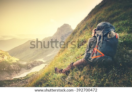 Man Traveler with big backpack relaxing Travel Lifestyle concept sunset mountains landscape on background Summer vacations adventure outdoor