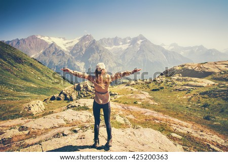 Happy Woman Traveler hands raised hiking with rocky mountains landscape Travel Lifestyle concept adventure summer vacations rear view