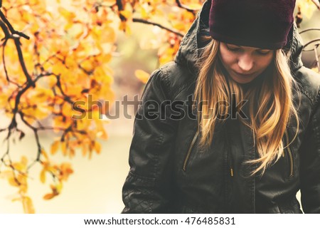 Sad Woman walking in park with autumn leaves on background outdoor Seasonal melancholy Lifestyle concept