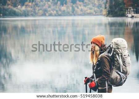 Woman with backpack hiking Lifestyle adventure concept forest and lake on background active vacations into the wild
