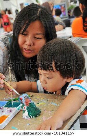 Child 2 years and mother painting in preschool