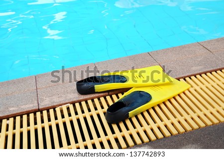 Yellow flipper near a swimming pool