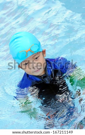 Portrait of four years old boy with swimming accessories
