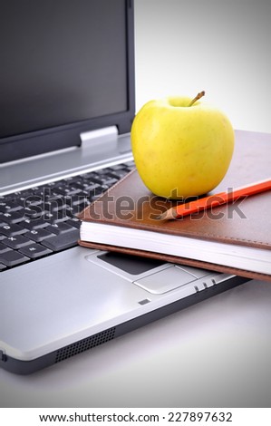 Notebook, apple and pen on the laptop. Education concept.