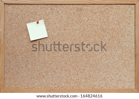 post it note pinned to a blank cork board / bulletin board with a wooden frame
