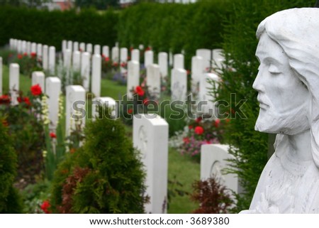 White gravestones of a WWI with statue of Jesus Christ in front