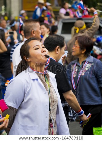 BANGKOK, THAILAND - NOVEMBER 27:An Unidentified woman blows a whistle to make symbolic protest against the amnesty bill on November 27, 2013 in the Ministry of industry\'s office in Bangkok, Thailand.
