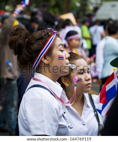 BANGKOK, THAILAND - NOVEMBER 27:An Unidentified girl blows a whistle to make symbolic protest against the amnesty bill on November 27, 2013 in the Ministry of industry\'s office in Bangkok, Thailand.