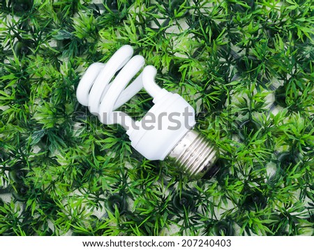 incandescence light bulb on artificial grass, green concept