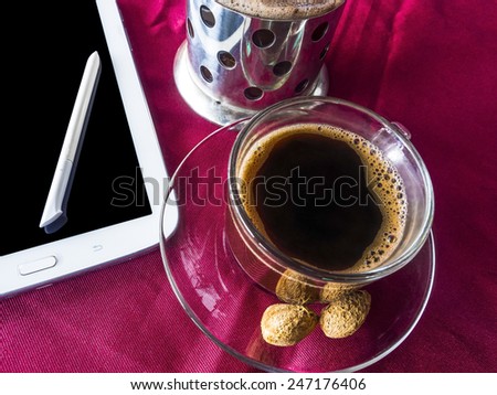 americano coffee on glass cup, ready to serve, with notepad and pen on red cloth table