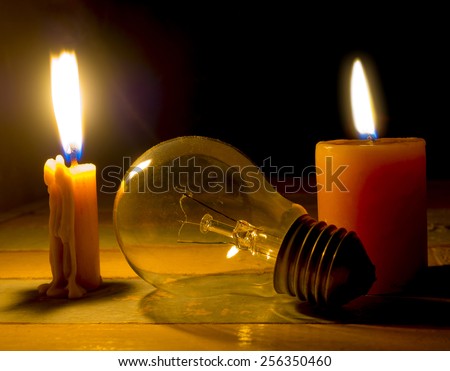 candle light shine on incandescent bulb, no electricity makes electrical equipment useless