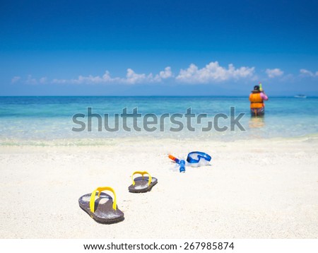 flip flop and dive equipment on white sand beach in the sea shore
