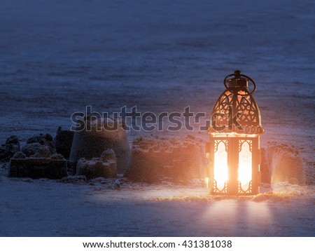 Lantern lighting with candle shining on sand ground, children play with it in Ramadan night, also known and called ramadan lantern