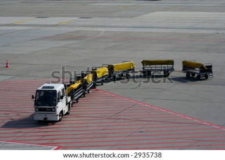 Luggage trailer car on a landing stripe.