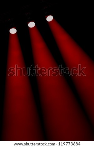 Three oblique individual red spotlight beams shining through a foggy darkness down towards the bottom right of the frame