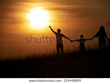 Silhouette of a happy family  with sunset background.