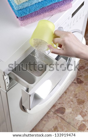 Woman pouring washing powder into the washing machine