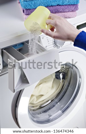 Woman hand pouring laundry detergent