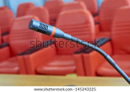 before a conference, the microphone in front of empty chairs.