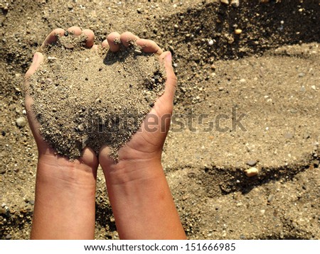 Closeup of a child hand, playing in the sand