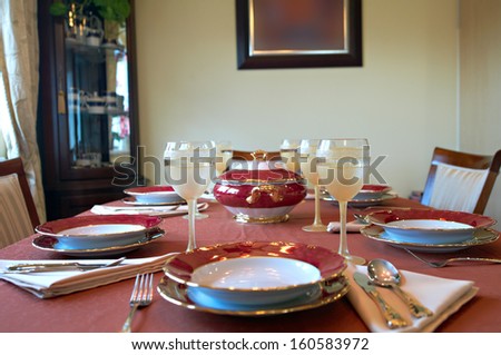 Elegant place setting with dishes over a red table cloth