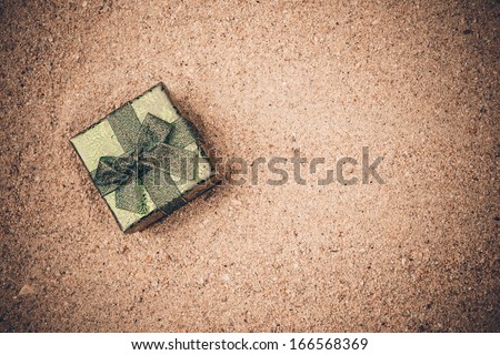Christmas gift box on the sand