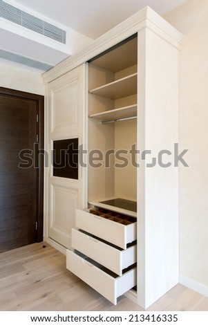 White closet with sliding doors, drawer and shelves