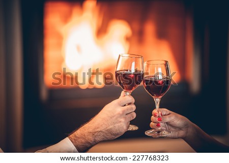 glasses of red wine and romantic fireplace