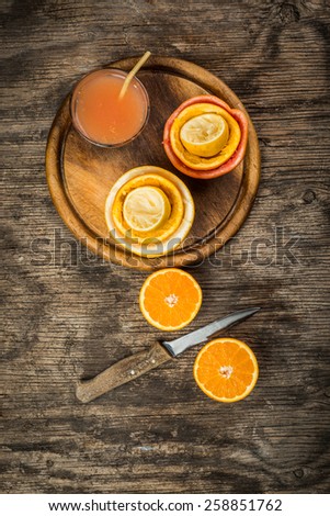 Citrus juice and fruits on vintage wooden background