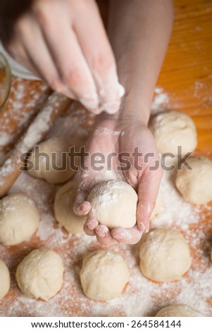balls of dough covered with wheat flour ready for baking
