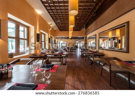 Cafe restaurant interior with wooden furniture, lighting equipment and decoration.