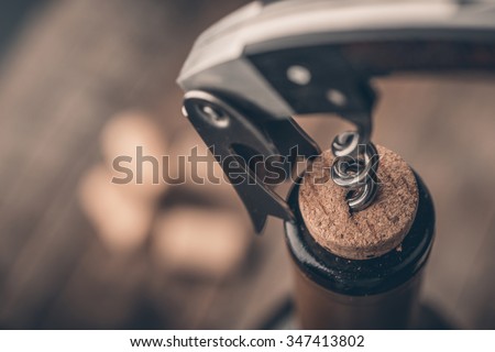 Opening a wine bottle with a corkscrew in a restaurant