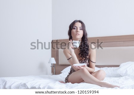 Beautiful woman drinking coffee in bedroom