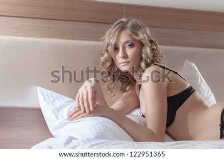 young woman posing in evening bed
