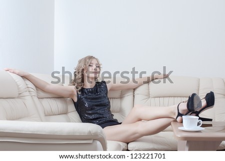 tall woman in black dress relax on sofa