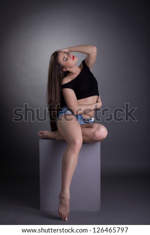 Sexy brunette woman  undress black top on cube