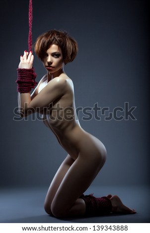 Image of skinny nude woman tied with rope